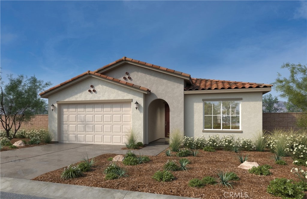 mediterranean / spanish house featuring concrete driveway, fence, stucco siding, and a garage