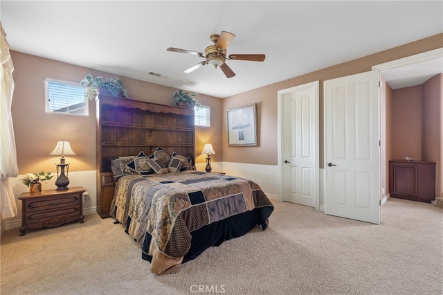 bedroom with a ceiling fan, multiple windows, visible vents, and carpet