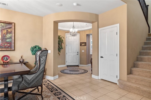 foyer entrance featuring stairway, light tile patterned floors, baseboards, visible vents, and a notable chandelier