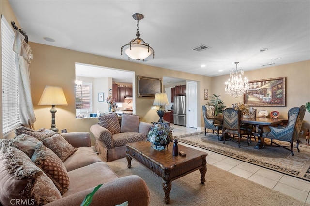 living area with a chandelier, visible vents, and light tile patterned floors