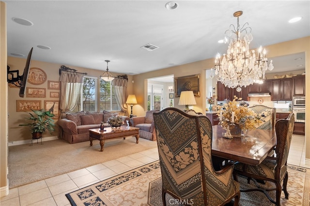 dining area with light carpet, light tile patterned flooring, baseboards, visible vents, and a chandelier