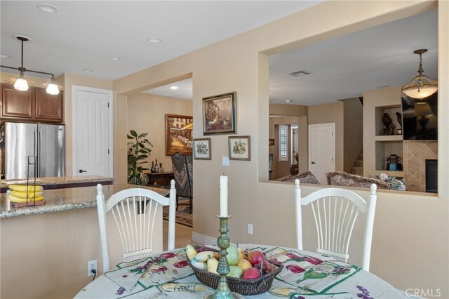 dining area featuring baseboards, recessed lighting, visible vents, stairs, and a fireplace
