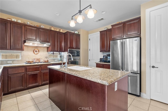 kitchen with light tile patterned floors, under cabinet range hood, appliances with stainless steel finishes, a sink, and visible vents