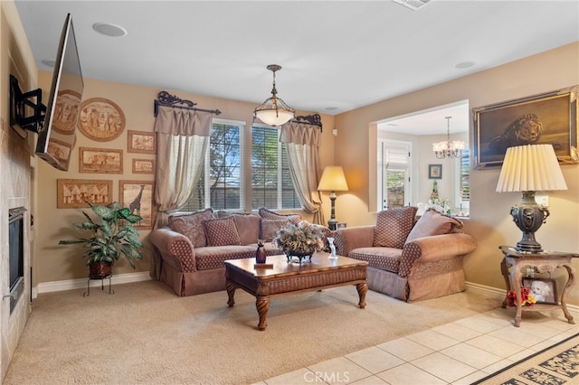 tiled living room featuring a glass covered fireplace, baseboards, carpet flooring, and a chandelier