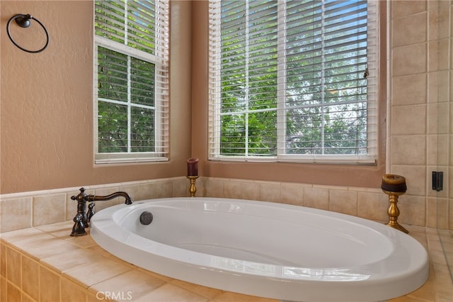 full bathroom with a bath and a textured wall