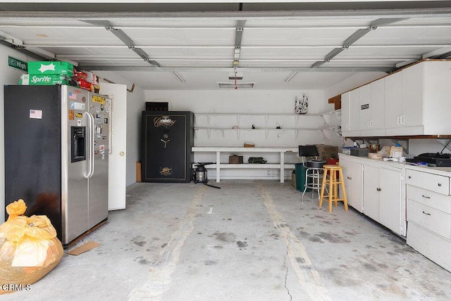 garage with stainless steel fridge with ice dispenser