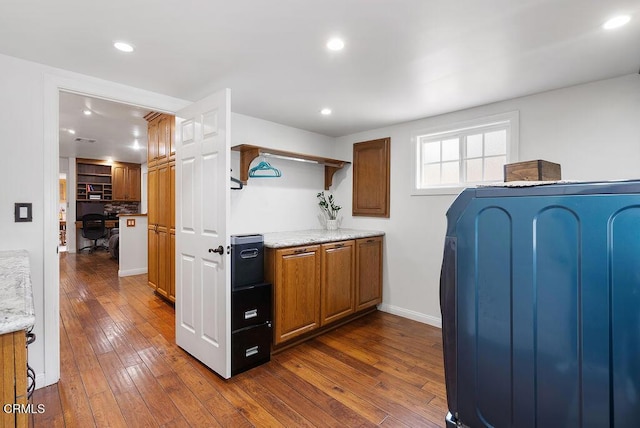 kitchen with brown cabinetry, recessed lighting, and dark wood-type flooring