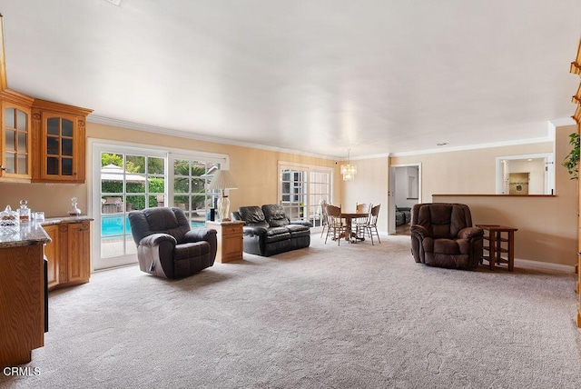 living area with ornamental molding, light colored carpet, and a chandelier