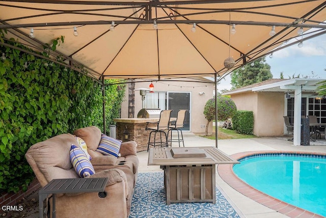 view of swimming pool featuring an outdoor hangout area, outdoor dry bar, a gazebo, and a patio area