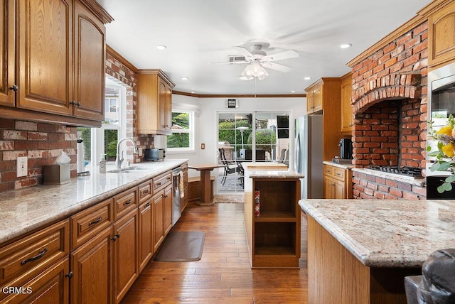 kitchen featuring tasteful backsplash, open shelves, hardwood / wood-style flooring, a sink, and stainless steel appliances