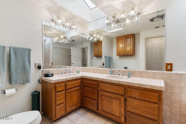 full bathroom with tile patterned flooring, a sink, a notable chandelier, and visible vents