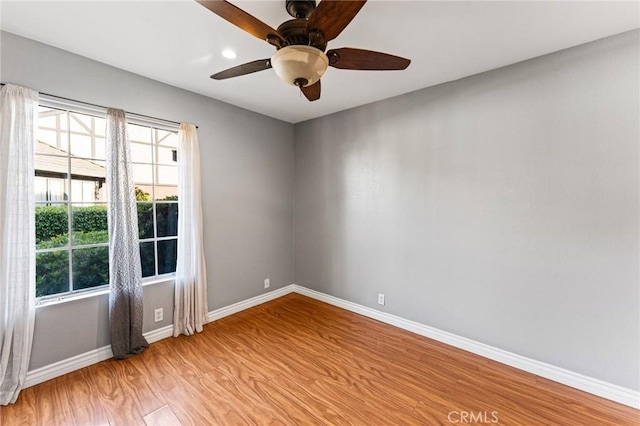 empty room featuring light wood-style flooring, baseboards, and ceiling fan