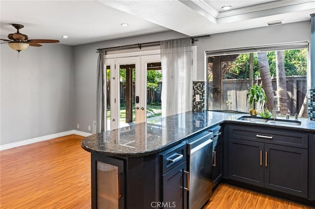kitchen with light wood-type flooring, a ceiling fan, a sink, and french doors