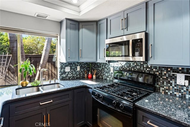 kitchen with dark stone countertops, black gas range, a sink, and stainless steel microwave