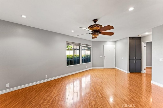 empty room with ceiling fan, baseboards, light wood-style floors, and recessed lighting