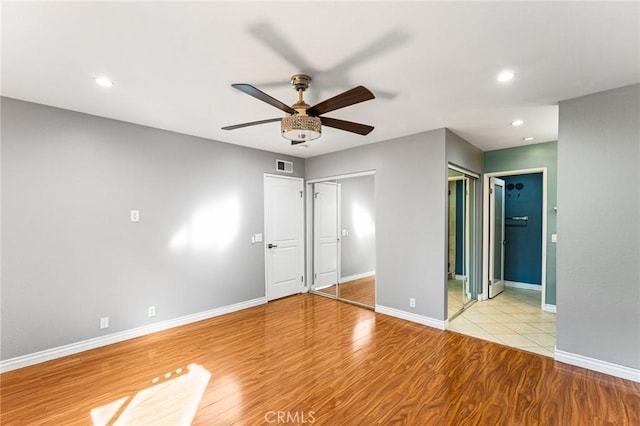 unfurnished bedroom featuring baseboards, wood finished floors, visible vents, and recessed lighting