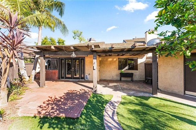 rear view of house with fence, a patio area, french doors, and stucco siding