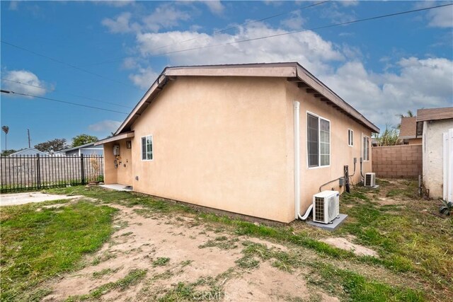 1181 W 4th St, Pomona, CA 91766 - view of side of home with fence, ac unit, central AC, and stucco siding