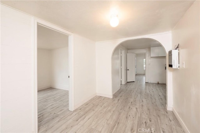 1181 W 4th St, Pomona, CA 91766 - corridor featuring baseboards, arched walkways, and light wood-style flooring