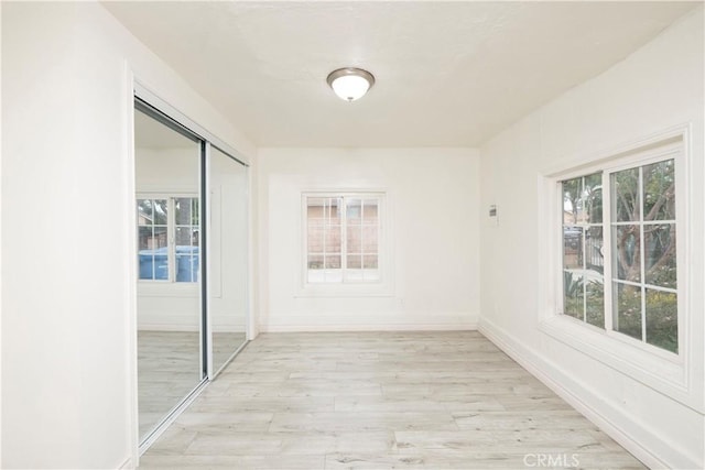 1181 W 4th St, Pomona, CA 91766 - corridor with baseboards, a healthy amount of sunlight, and light wood-style flooring