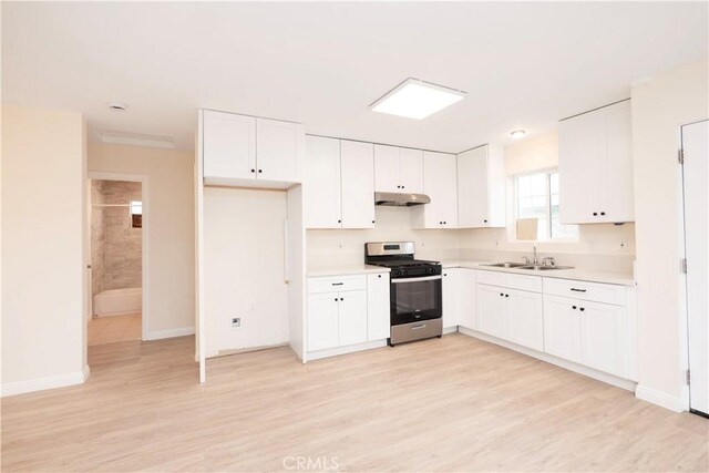 1181 W 4th St, Pomona, CA 91766 - kitchen with light wood finished floors, under cabinet range hood, stainless steel gas range oven, light countertops, and a sink