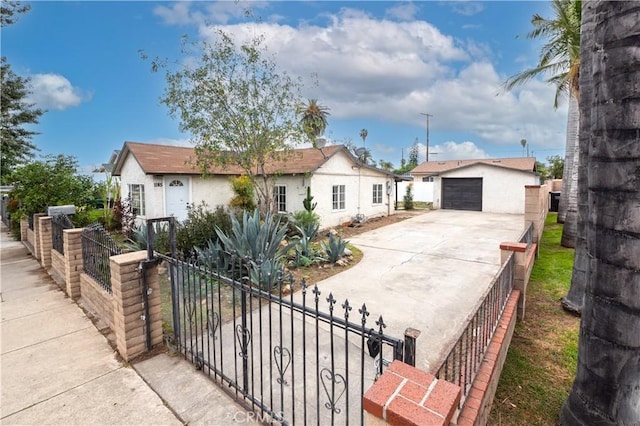 1181 W 4th St, Pomona, CA 91766 - view of front of home with a fenced front yard, stucco siding, driveway, an outdoor structure, and a detached garage
