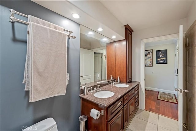 full bathroom featuring recessed lighting, toilet, double vanity, baseboards, and tile patterned flooring
