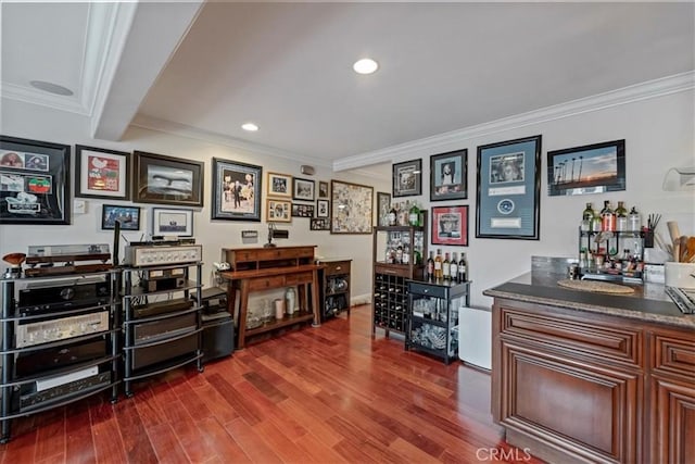 indoor bar with ornamental molding, dark wood-type flooring, and recessed lighting