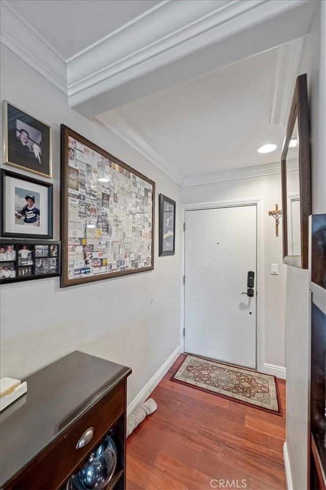 entryway featuring baseboards, wood finished floors, ornamental molding, and recessed lighting