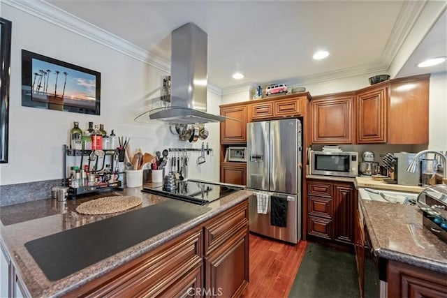 kitchen with appliances with stainless steel finishes, island range hood, crown molding, dark wood finished floors, and brown cabinets