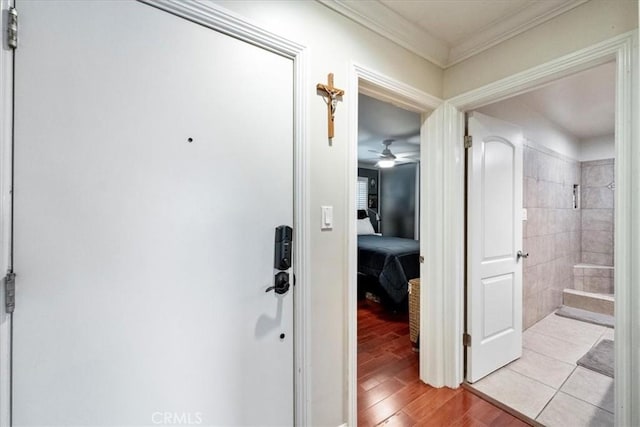 corridor featuring light wood-style floors and ornamental molding