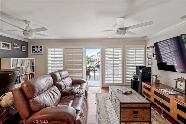 living area featuring a ceiling fan, crown molding, and wood finished floors