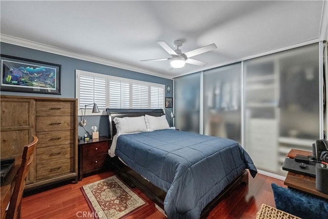bedroom with ornamental molding, wood finished floors, and ceiling fan