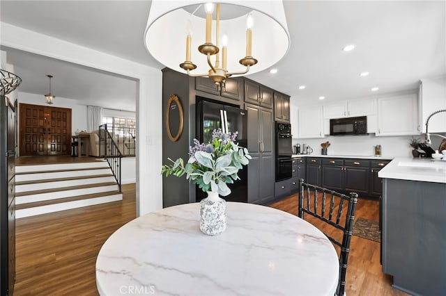 dining area with stairs, recessed lighting, a chandelier, and dark wood-style flooring