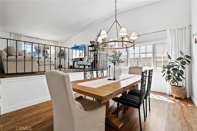 dining space with a notable chandelier, wood finished floors, and baseboards