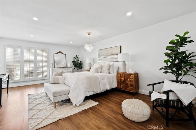 bedroom with a notable chandelier, dark wood-style floors, and recessed lighting