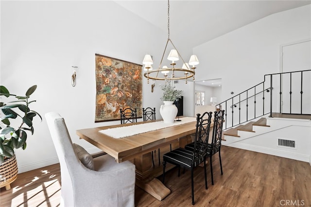 dining room with high vaulted ceiling, wood finished floors, a chandelier, baseboards, and visible vents