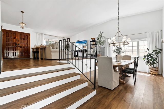 interior space featuring vaulted ceiling, wood finished floors, and an inviting chandelier