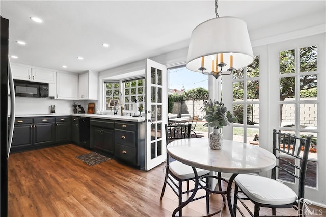 kitchen featuring white cabinetry, light countertops, black appliances, recessed lighting, and dark wood finished floors