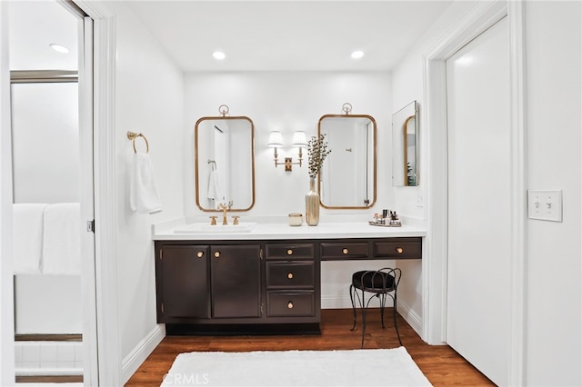 full bathroom featuring wood finished floors, vanity, recessed lighting, and baseboards
