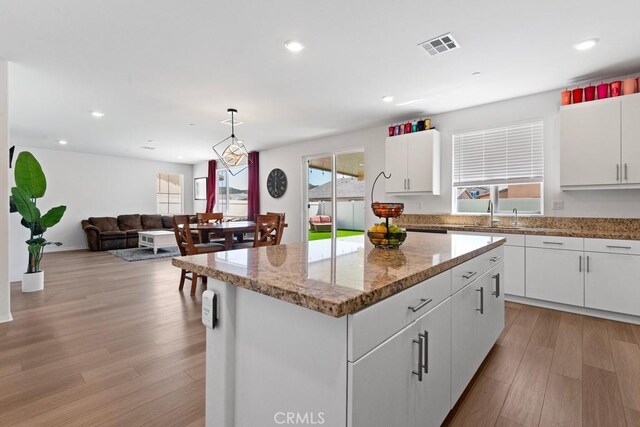 5085 Hoss Cir, Hemet, CA 92545 - kitchen featuring a kitchen island, light wood-style flooring, white cabinets, recessed lighting, and light stone counters