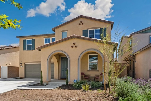 5085 Hoss Cir, Hemet, CA 92545 - mediterranean / spanish house featuring stucco siding, an attached garage, driveway, a porch, and a tile roof