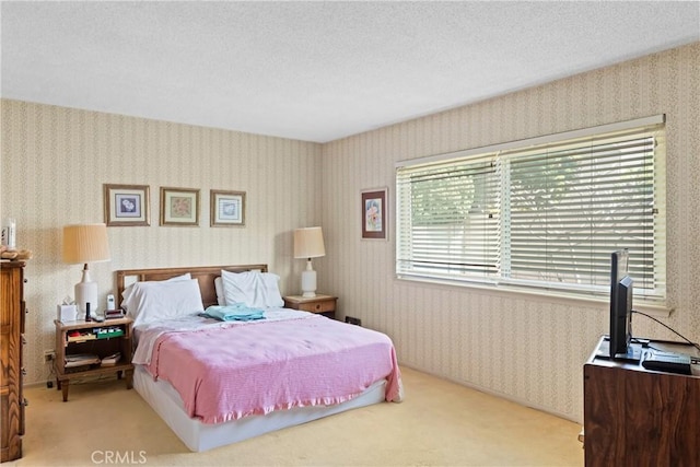 bedroom featuring wallpapered walls, carpet flooring, and a textured ceiling