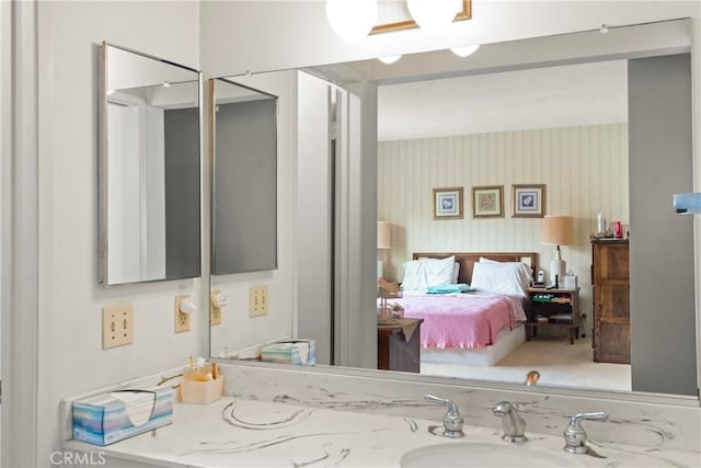 bathroom with vanity and wallpapered walls