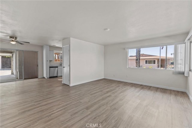 603 S Palm Ave Unit A, Hemet, CA 92543 - unfurnished living room featuring ceiling fan, baseboards, plenty of natural light, and light wood-style flooring