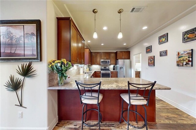 117 Village Cir, Pismo Beach, CA 93449 - kitchen with visible vents, dark wood-style flooring, a peninsula, a sink, and stainless steel appliances