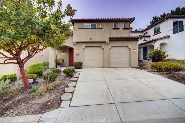 117 Village Cir, Pismo Beach, CA 93449 - mediterranean / spanish-style house with an attached garage, stucco siding, concrete driveway, and a tile roof