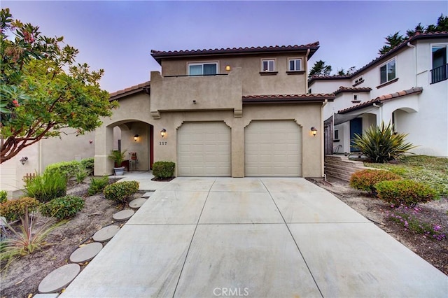 117 Village Cir, Pismo Beach, CA 93449 - mediterranean / spanish-style home featuring a garage, stucco siding, a tiled roof, and driveway