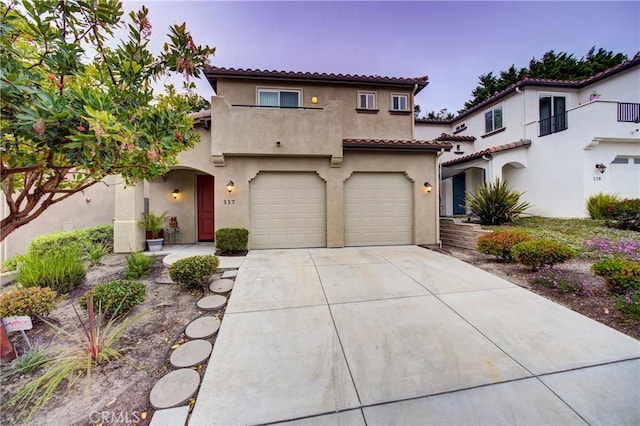 117 Village Cir, Pismo Beach, CA 93449 - mediterranean / spanish house featuring a tiled roof, a balcony, concrete driveway, an attached garage, and stucco siding