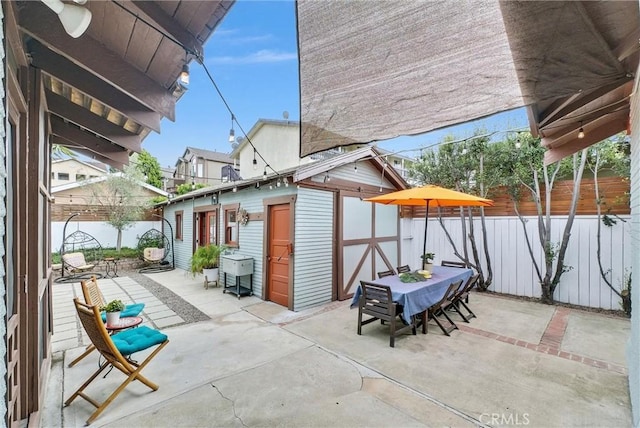 524 Walnut Ave, Long Beach, CA 90802 - view of patio with a fenced backyard, an outbuilding, outdoor dining space, and a shed